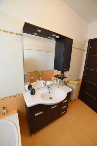 a bathroom with a sink and a large mirror at Casa Rosanna in Giardini Naxos