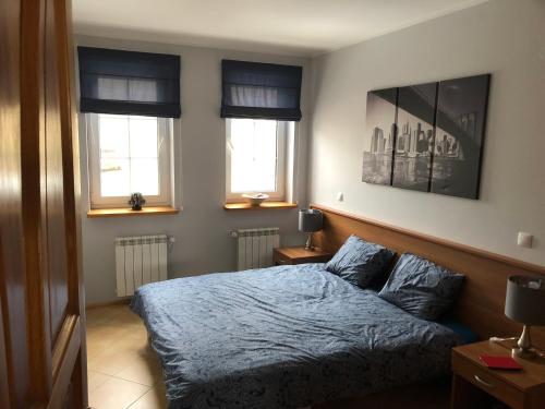 una camera da letto con letto con lenzuola e finestre blu di Apartament Dadaj 2/5 a Dadaj