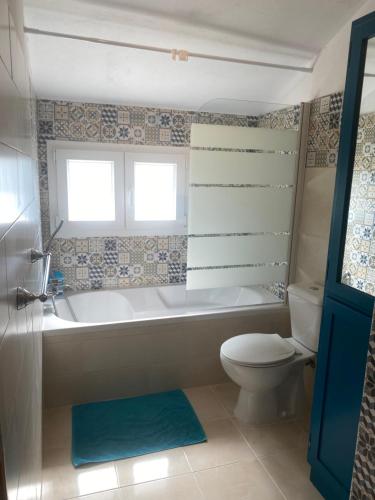 a bathroom with a tub and a toilet and a sink at Quinta de Areias in Crespos