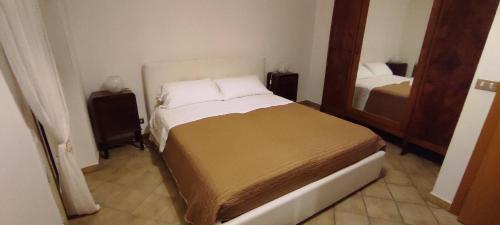ein kleines Schlafzimmer mit einem Bett und einem Spiegel in der Unterkunft Da Elena in SantʼAngelo Muxaro