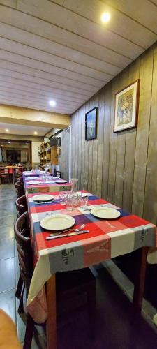 une longue table avec des assiettes et des verres dans l'établissement Chambre d'hotes le cycliste, à La Chapelle