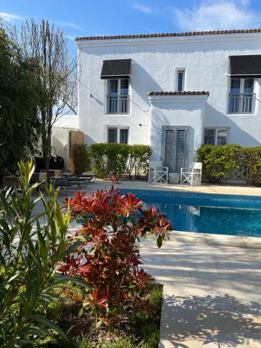 a white house with a swimming pool in front of it at Tagoo Vama Veche in Vama Veche