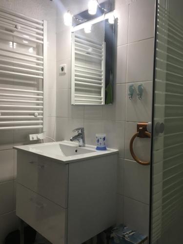 une salle de bain blanche avec un lavabo et un miroir dans l'établissement Agriates, à Patrimonio