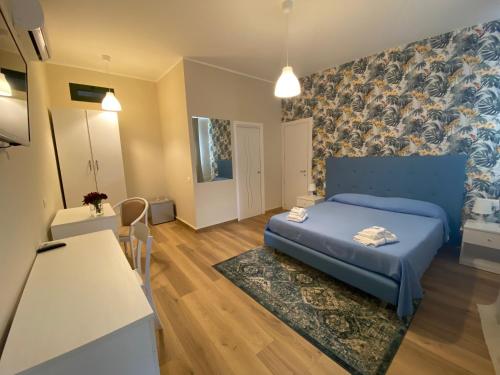 1 dormitorio con 1 cama azul y cocina en Masseria Nobile Relais, en Fisciano