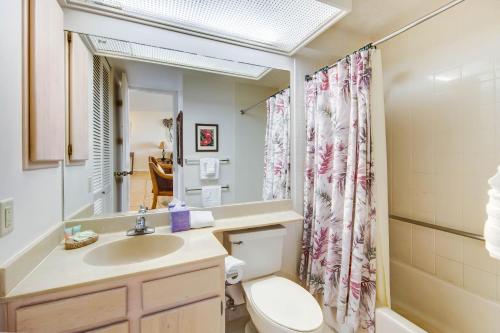 a bathroom with a sink and a toilet and a mirror at Cliffs 5205 Condo in Princeville