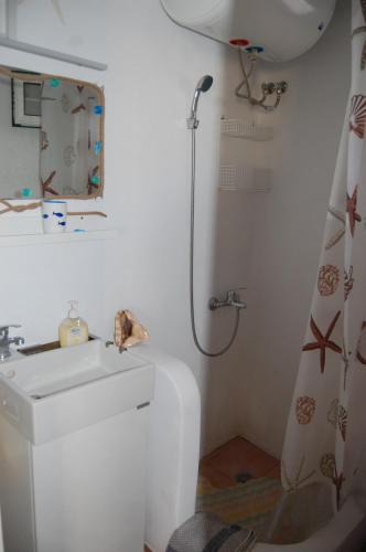 a bathroom with a sink and a shower at COSY STUDIO IN ALLOPRONOIA SIKINOS in Alopronia