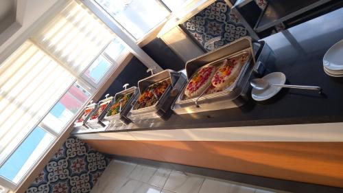 a buffet with three trays of food on a counter at Galaxy Beach Hotel Alanya in Mahmutlar