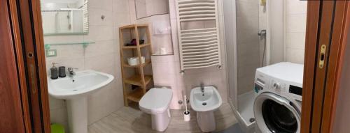 uma casa de banho com um WC e uma máquina de lavar roupa. em Taste of Trieste Center em Trieste