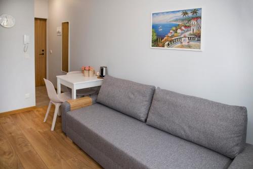 a living room with a gray couch and a table at Pepleri Studio 7 in Tartu