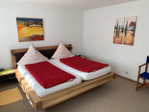 バーデン・バーデンにあるFerienwohnung am Krippenhofのベッドルーム1室(赤い枕のベッド2台付)