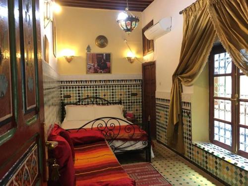 ein Schlafzimmer mit einem Bett in der Ecke eines Zimmers in der Unterkunft Dar Fès Huda in Fès
