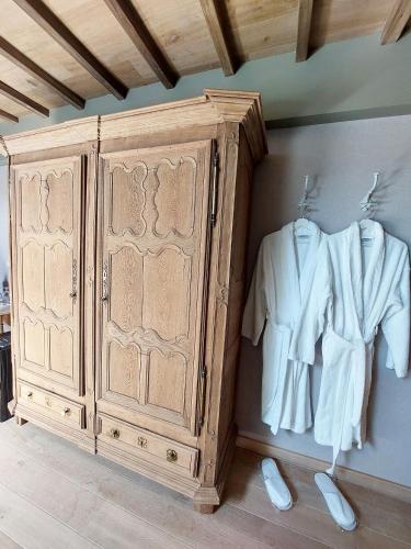 a wooden cabinet with a shirt hanging next to it at Cha Cha de Loup Luxe B&B - Vakantiewoning in Rendeux