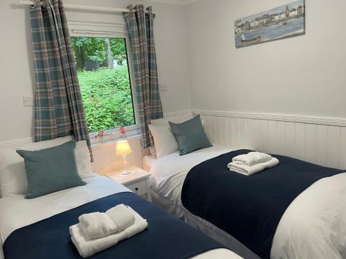 two twin beds in a room with a window at Seaside Escape in St Ives
