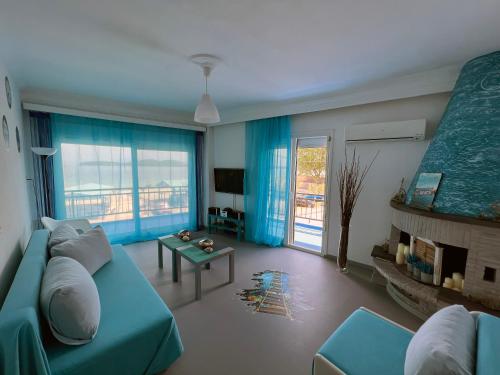 Upper Deck Apt. في ني بيراموس: غرفة معيشة مع أريكة زرقاء ومدفأة