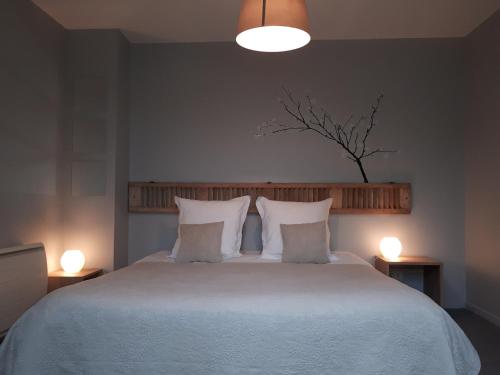a bedroom with a large white bed with two lamps at Apt 8 du Temple HyperCentre & Parking in Cambrai