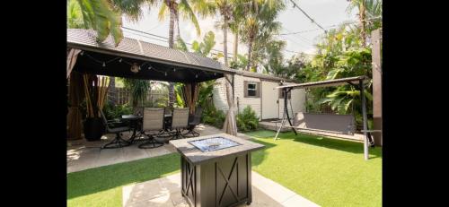 a backyard with a table in the grass at HEART OF WILTON MANORS in Fort Lauderdale