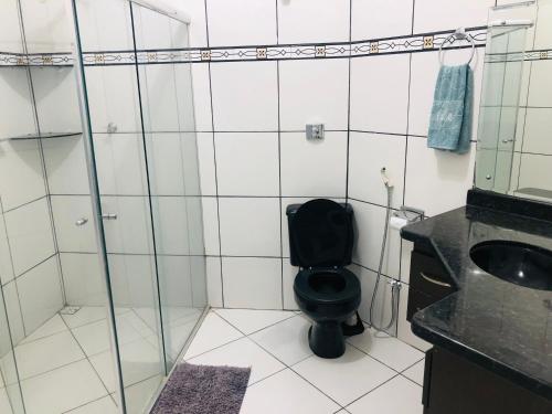 uma casa de banho com um WC preto e um lavatório. em Casa em bairro nobre - Caçari em Boa Vista