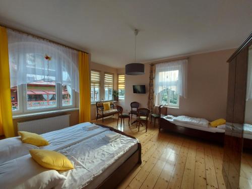 een slaapkamer met een bed en een woonkamer bij Pension Etiuda in Duszniki Zdrój