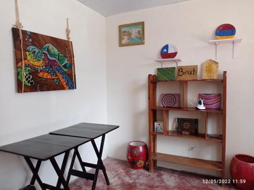 une salle à manger avec une table et une étagère dans l'établissement Alquiler de habitaciones BAY HOUSE HOSTEL, à Salinas