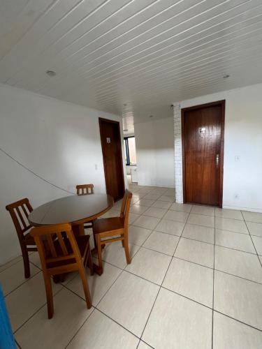 a dining room with a table and two chairs at Tortuguita Ossos - Suítes in Búzios