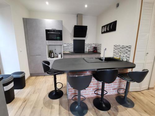 a kitchen with a black table and stools at Appartement Fontargente in Ax-les-Thermes
