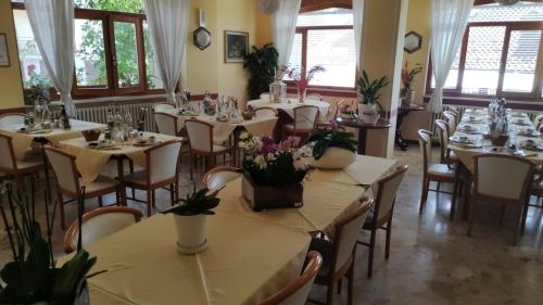 a restaurant with tables and chairs with flowers on them at Hotel Rosalpina in Serina