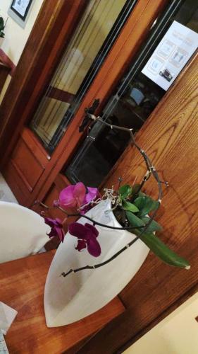 a white vase with flowers in it on a table at Hotel Rosalpina in Serina