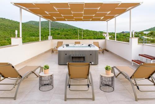 a patio with chairs and a table on a roof at Apartment Solis (****) in Prgomet