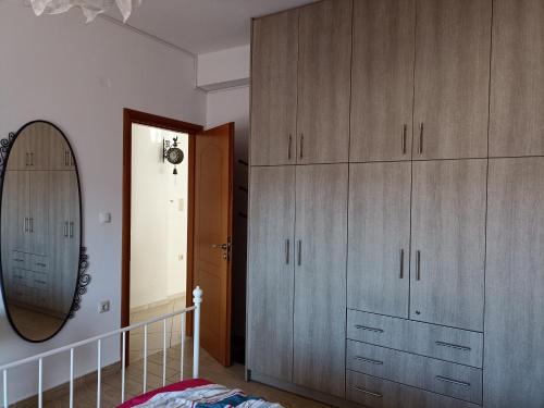 a bedroom with wooden cabinets and a mirror at Cozy house Ioannina neokesaria in Neokaisáreia