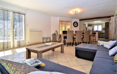 a living room with a blue couch and a table at Awesome Home In Slaurent-La-Vernede in Fontarèches