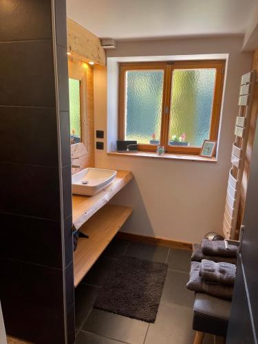 une salle de bain avec un lavabo, un miroir et une fenêtre dans l'établissement Appartement de montagne au Chalet de Snow, à Xonrupt-Longemer