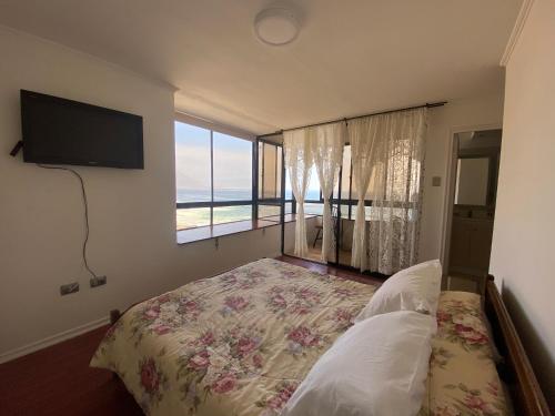 a bedroom with a bed and a large window at En Iquique, Chile, depto diario frente a playa Brava in Iquique