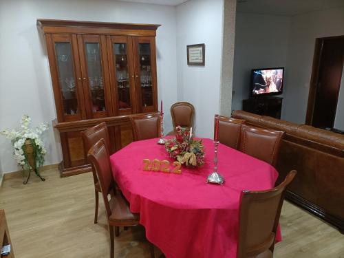 a dining room with a table with a pink table cloth at Casa Amarela da Caniçada in Vieira do Minho