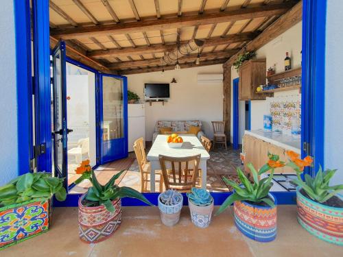 Granitola的住宿－Villa Nica，客厅配有桌子和一些盆栽植物