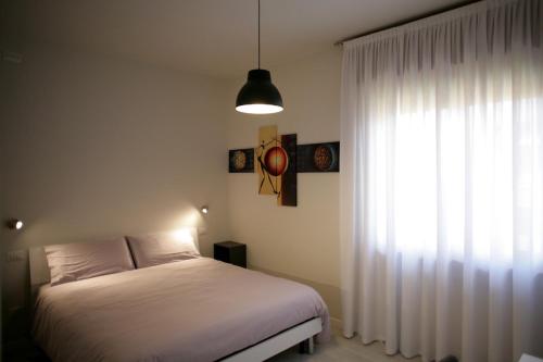 a bedroom with a white bed and a window at Melograno Rooms B&B in Brogliano