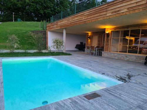 a swimming pool in front of a house at Liebe zur Steiermark / Haus Tyrol in Jagerberg