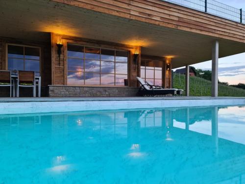 a swimming pool in front of a house at Liebe zur Steiermark / Haus Tyrol in Jagerberg
