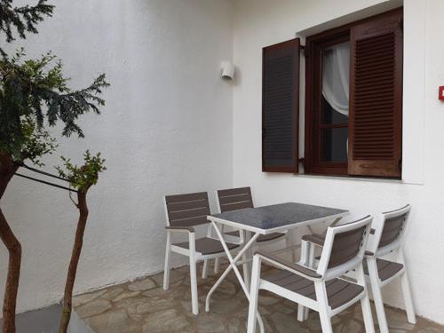 a table and chairs sitting next to a building at Skiathos Maria Apartments in Skiathos