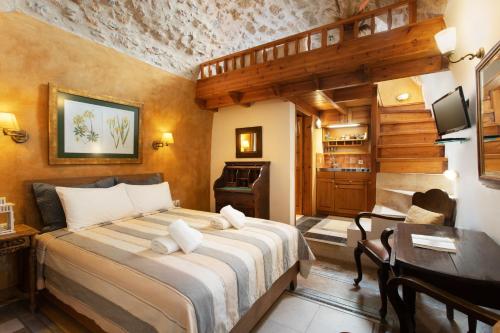 a bedroom with a bed and a table and a desk at Dorovinis Monemvasia Castlehouses in Monemvasia