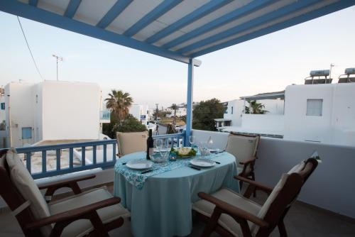 a table with a blue table cloth on a balcony at Escape to Mykonos - Entire place by Ornos beach in Ornos