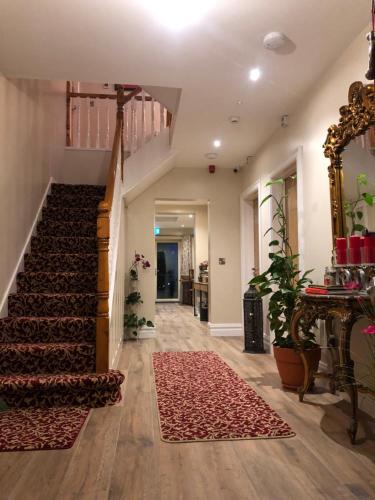 einen Flur eines Hauses mit einer Treppe und einem Teppich in der Unterkunft MapleHouse B&B in Drogheda