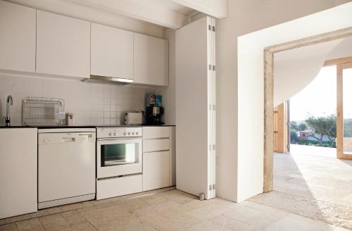 a kitchen with white appliances and an open doorway at Casas de Vale de Lobo in Mirandela
