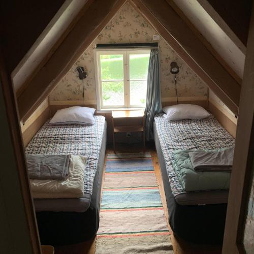 two beds in a room with a window at Sjöstuga vid Bunn Gränna - Uddastugan in Gränna