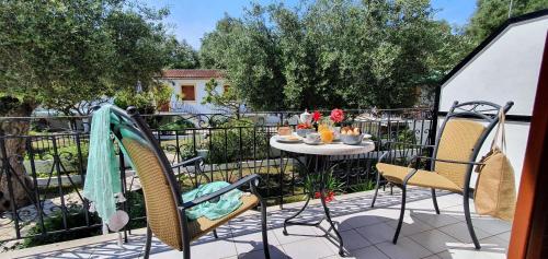 a patio with a table and chairs on a balcony at LIvadi Studios with Pool in Lákka