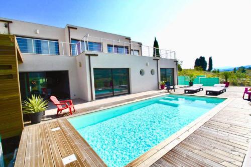 a villa with a swimming pool in front of a house at Havre de paix, vue pano, terrasse, piscine, nature. in Limoux