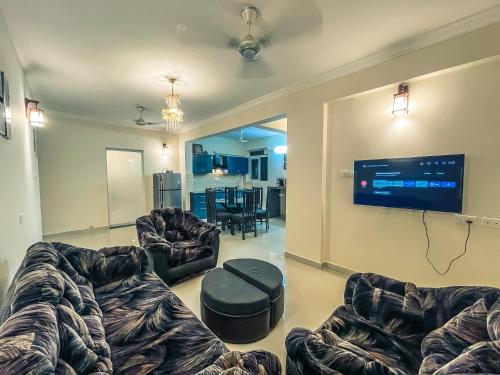 a living room with couches and a flat screen tv at Calvin's Retreat in Varca