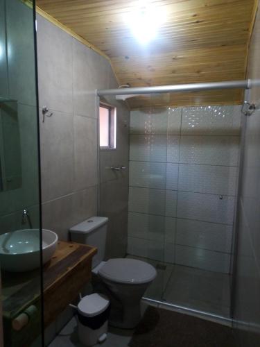 a bathroom with a toilet and a sink and a shower at Pousada Duplátanos in Monte Verde