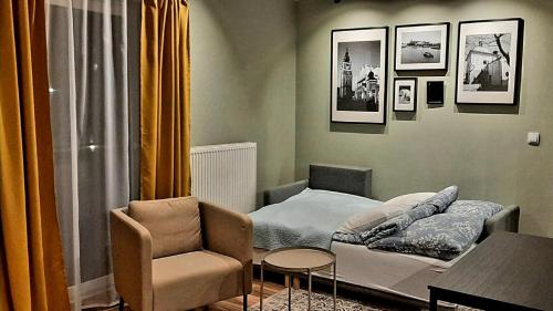 een kleine kamer met een bed en een stoel bij Wielicka Street Apartment in Krakau
