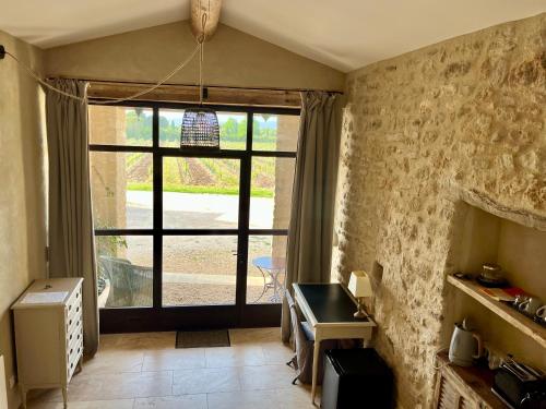 Habitación con una gran puerta de cristal y una ventana. en La Verrière à Bonnieux, en Bonnieux