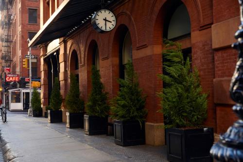 a clock on the side of a building with potted plants at The Mercer in New York